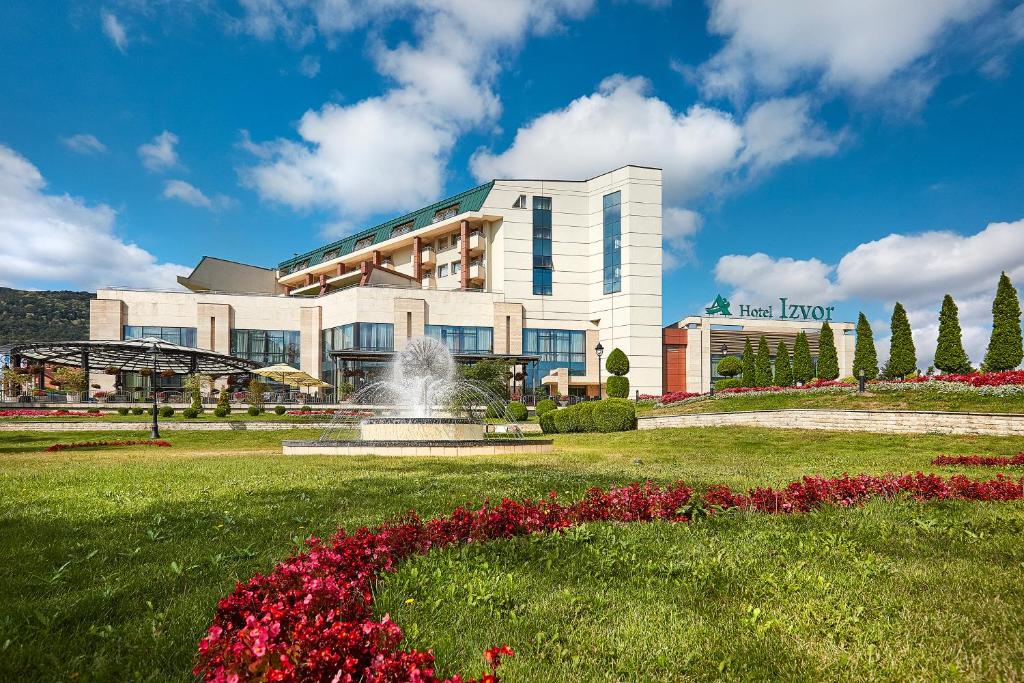 un hotel con una fuente frente a un edificio en A Hoteli - Hotel Izvor en Arandjelovac