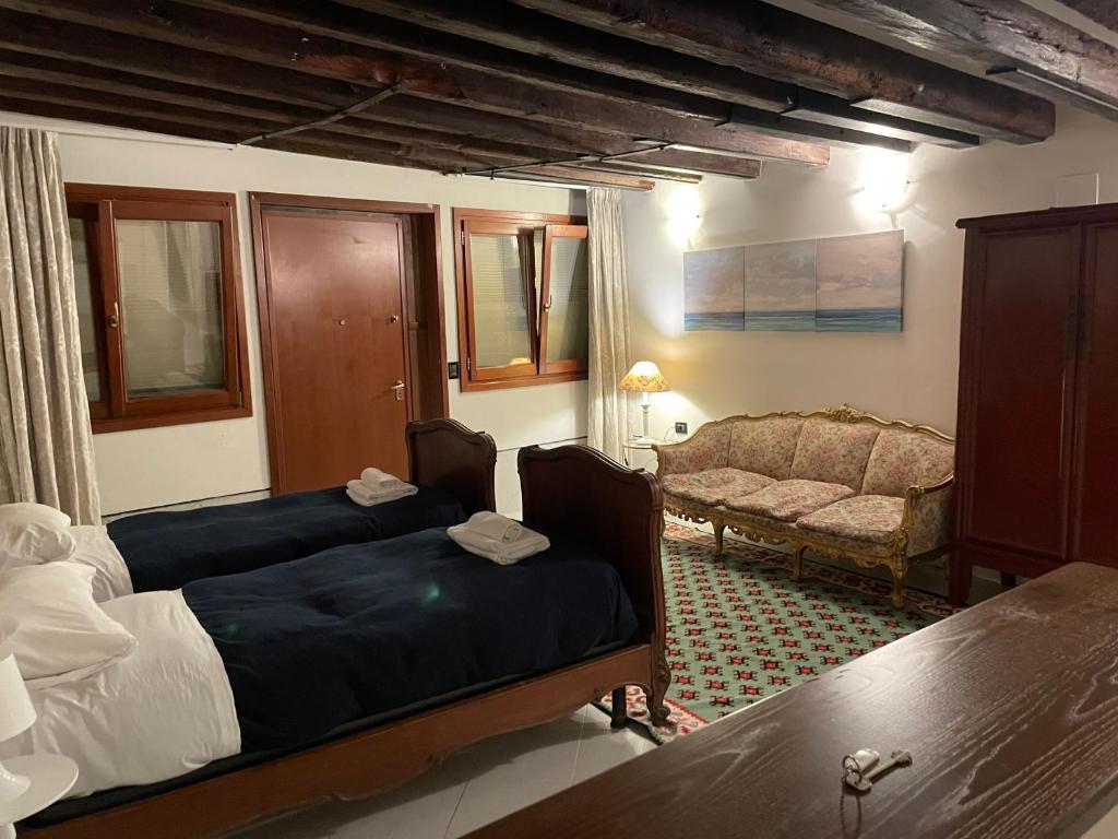 ein Wohnzimmer mit 2 Betten und einem Sofa in der Unterkunft Ca' Sant'Aponal 2 in Venedig