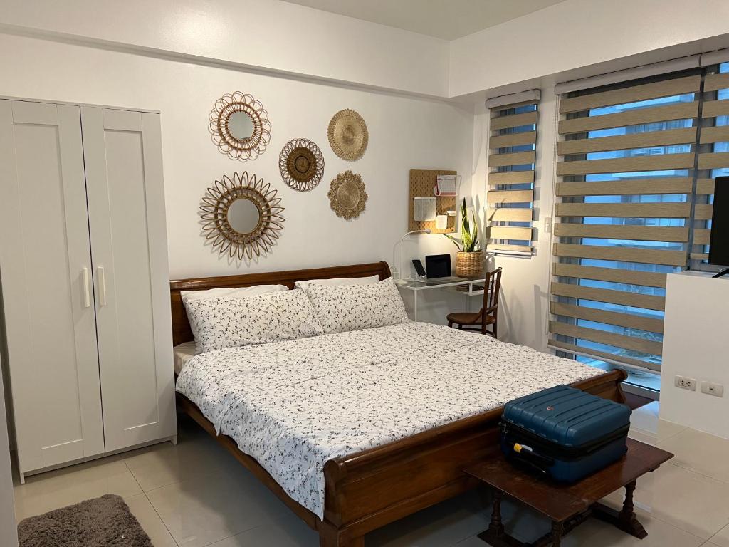 - une chambre avec un lit et une valise bleue dans l'établissement Telly's Studio Across NAIA3, à Manille