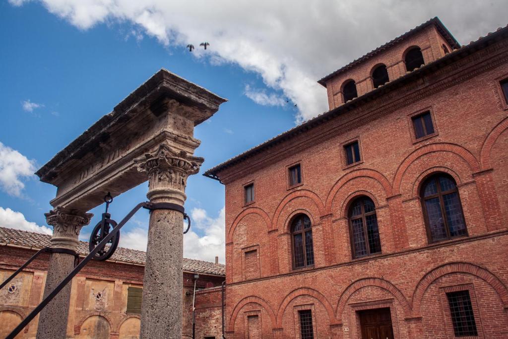 a building with a column and a brick building at Tenuta La Fratta in Sinalunga