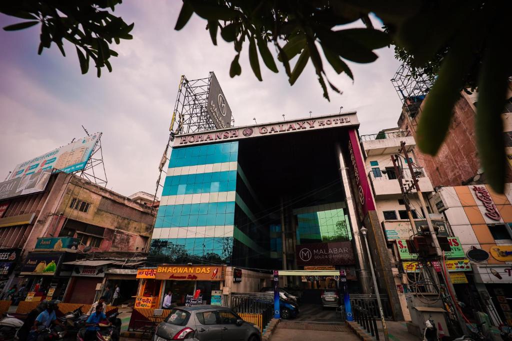 a building with a sign on it in a city at HOMANSH GALAXY HOTEL in Kānpur