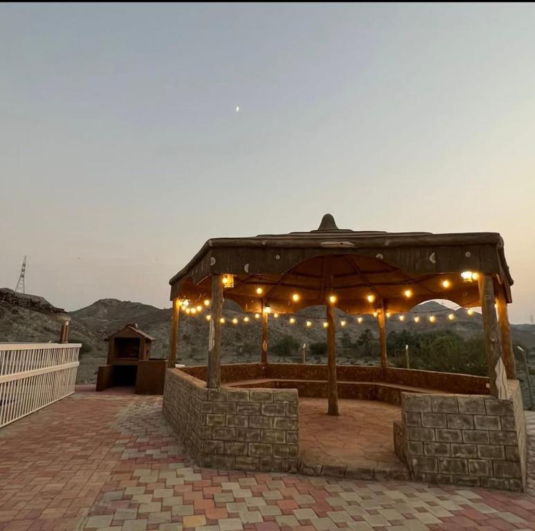 a gazebo with lights and chairs on a patio at The Fort Farm in Suḩaybah