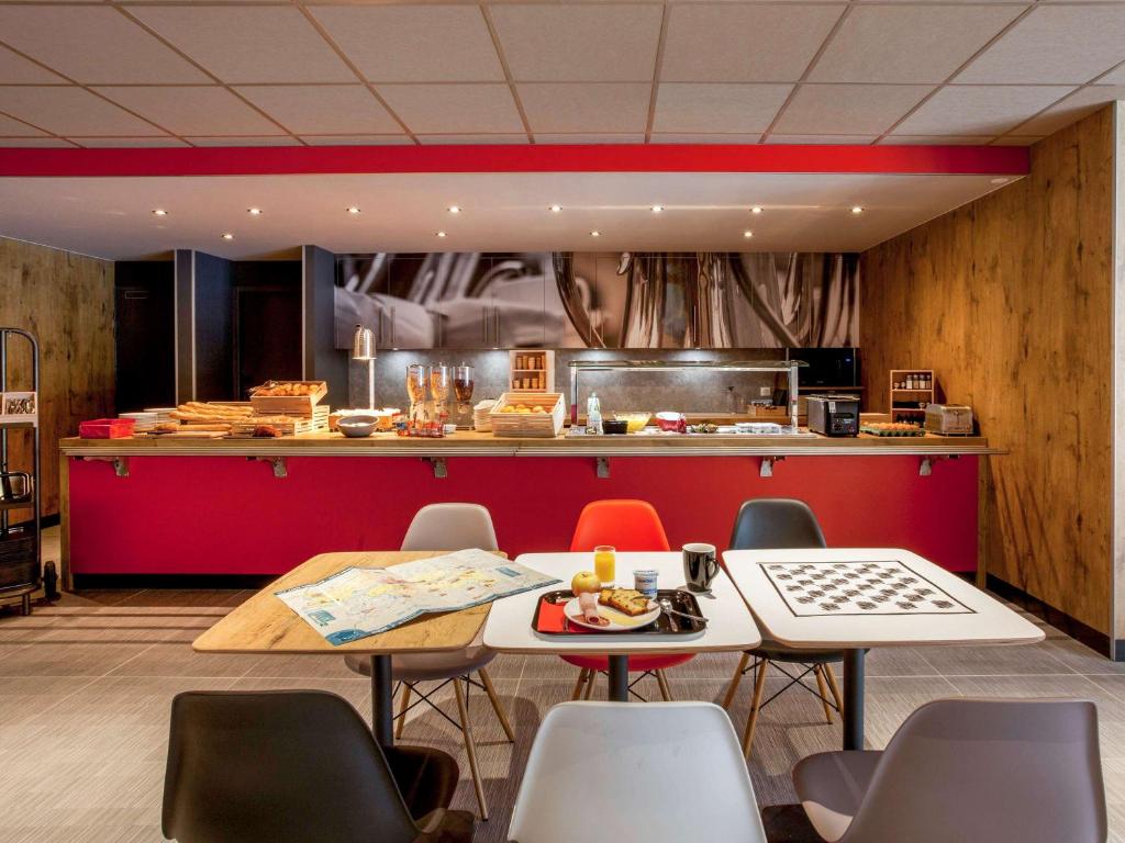ibis Cahors في كاهور: مطعم بطاولة وكراسي وكاونتر
