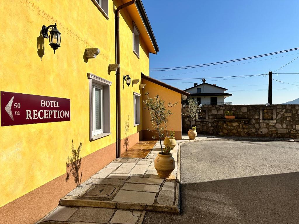 a yellow building with a sign on the side of it at Hotel Grahor Depandance in Sežana