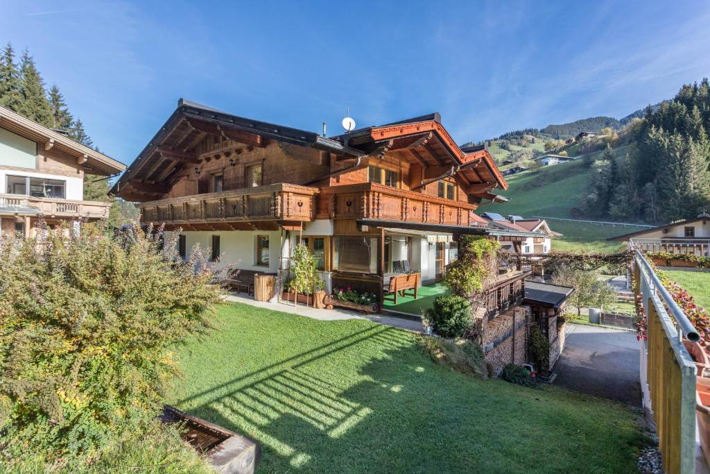 a large wooden house with a green yard at Ferienwohnung Hörbiger in Wildschönau