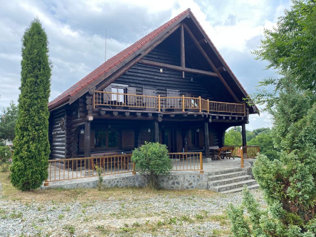 a large log cabin with a porch and a deck at Chalet 33 - Spacious, cosy and a wonderful view in Predeluţ