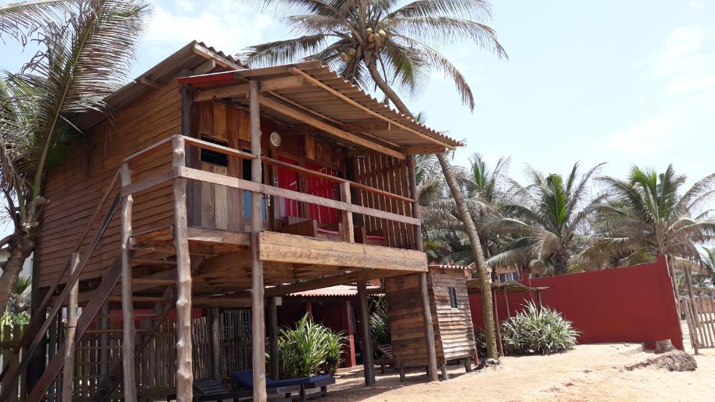 a wooden house on the beach with palm trees at CASE de ROBINSON in Lomé
