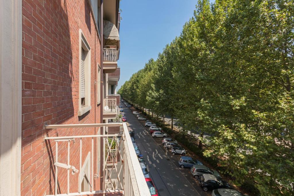 una strada cittadina con auto parcheggiate sul lato di un edificio di Appartamento Agnelli vicino al Pala Alpitour by Wonderful Italy a Torino