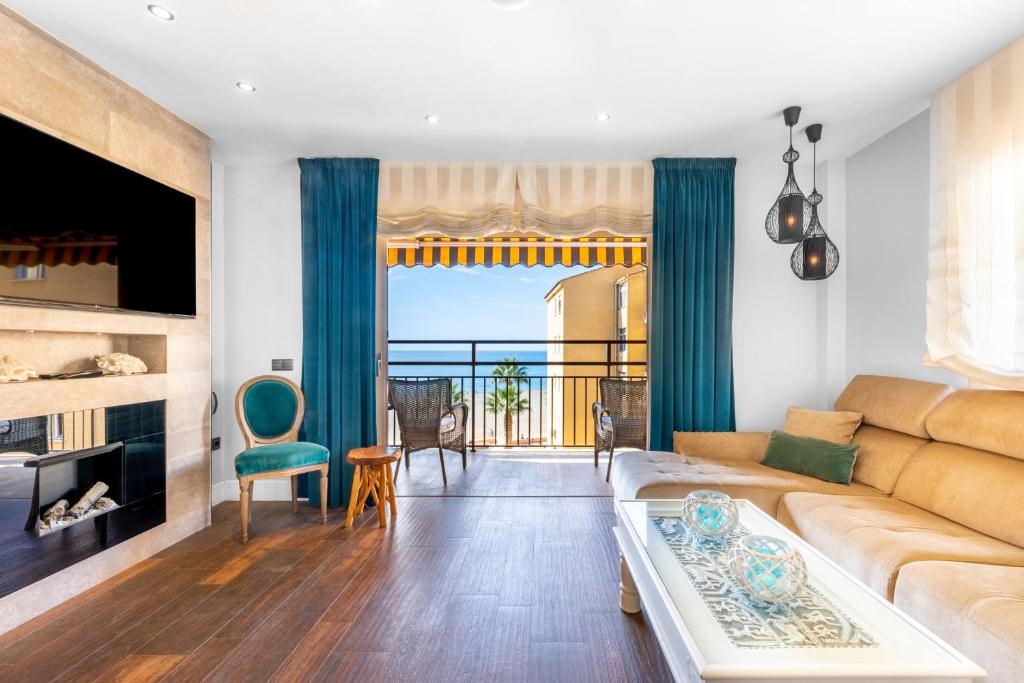 een woonkamer met een bank en uitzicht op de oceaan bij WintowinRentals Increible Apartamento & Mejor ubicación in Cala del Moral