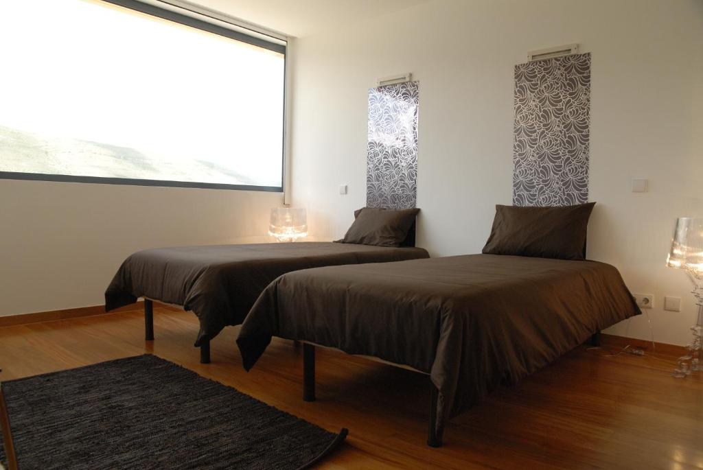 two beds in a room with a window at HI Alvados - Pousada de Juventude in Alvados