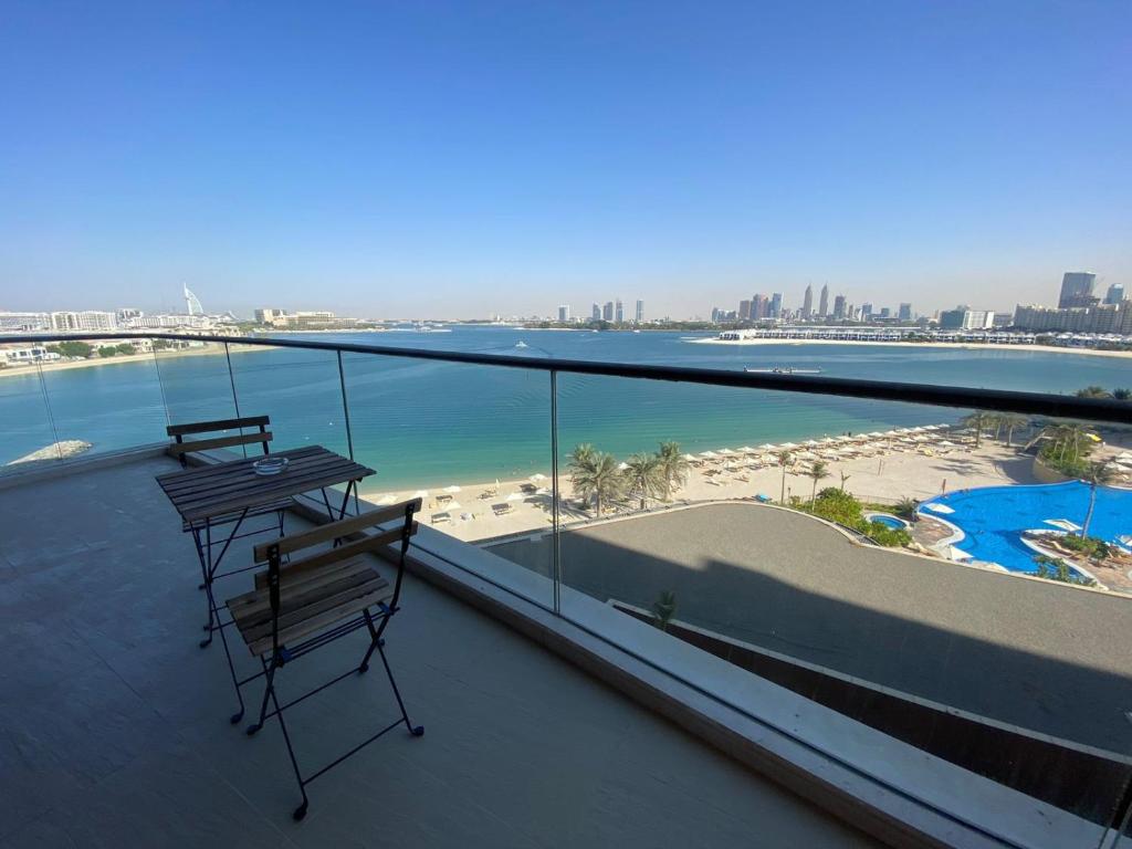 a balcony with two benches and a view of the beach at Tiara Emerald - 1BR Apartment - Allsopp&Allsopp in Dubai