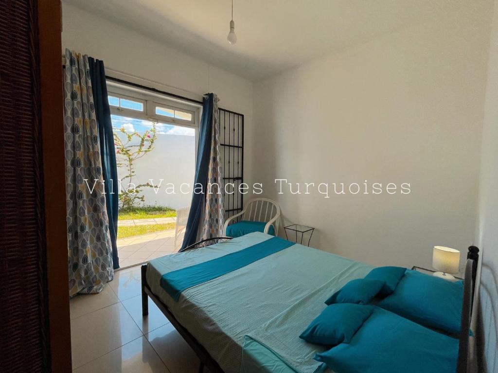 a bedroom with a bed and a large window at Maison Familiale - Vacances Turquoises in Mahébourg