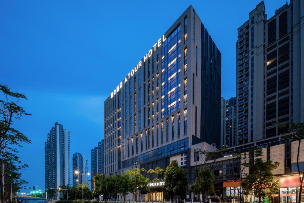 a tall building with lights on it in a city at Atour Hotel Anqing Municipal Affairs Center Seventh Street in Anqing