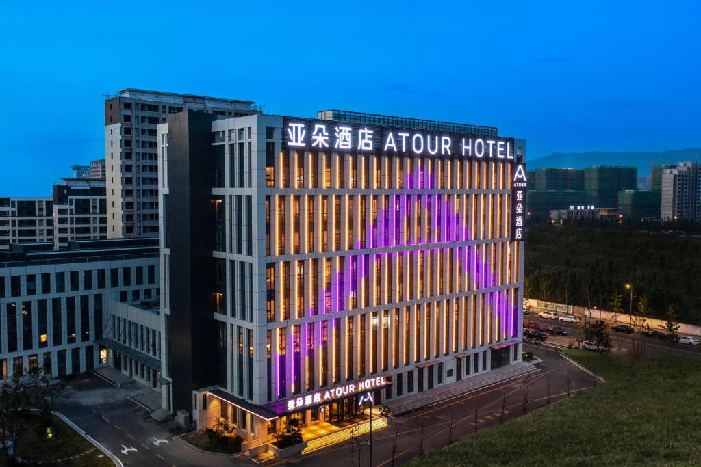 vistas a un edificio del hotel con iluminación púrpura en Atour Hotel Lianyungang Municipal Affairs Central University Town, en Lianyungang