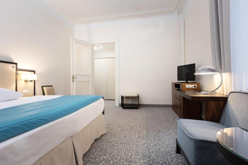 a hotel room with a bed and a couch at OREA Spa Hotel Bohemia Mariánské Lázně in Mariánské Lázně