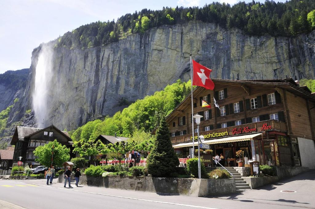 un hôtel arborant un drapeau canadien devant une cascade dans l'établissement Hotel Schützen Lauterbrunnen, à Lauterbrunnen