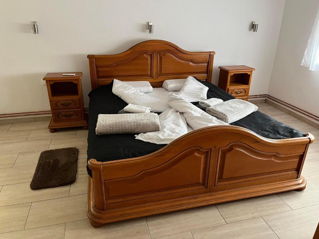 una gran cama de madera con almohadas blancas. en Sobe Tea, en Virovitica