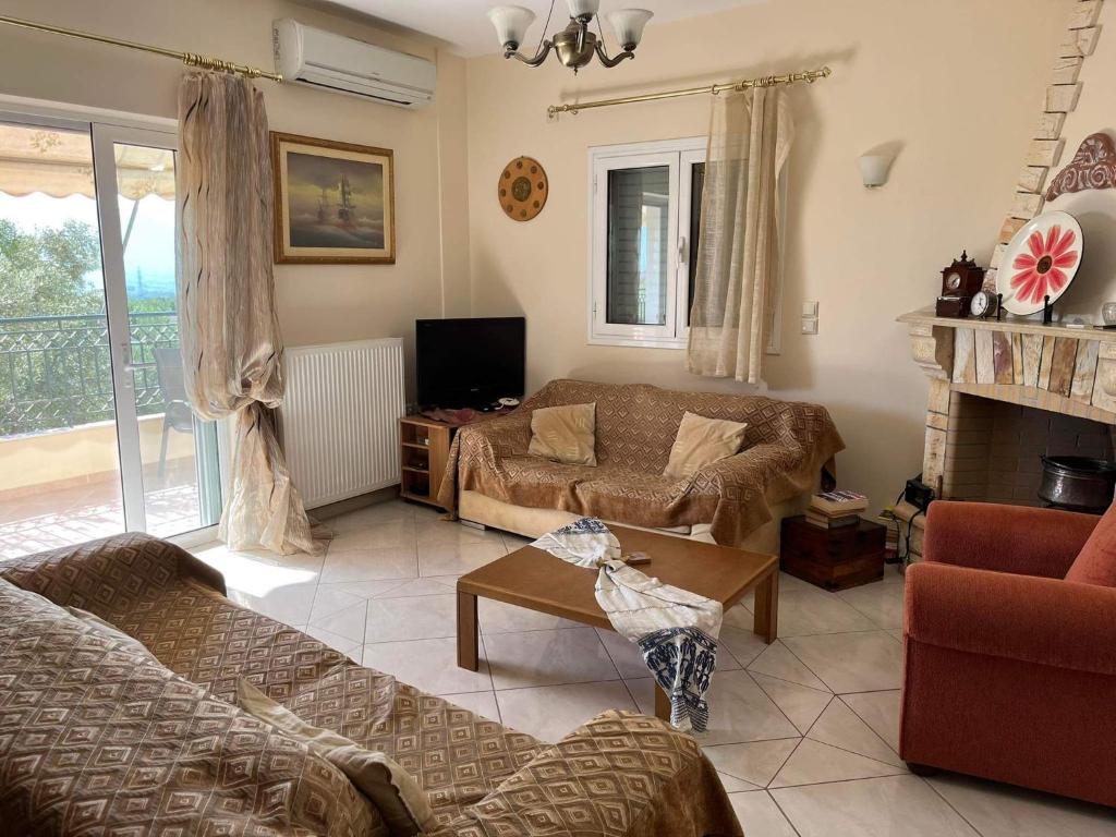 uma sala de estar com um sofá e uma lareira em Beautiful & cosy 5-Bedroom Villa - Peloponnese em Pídhima
