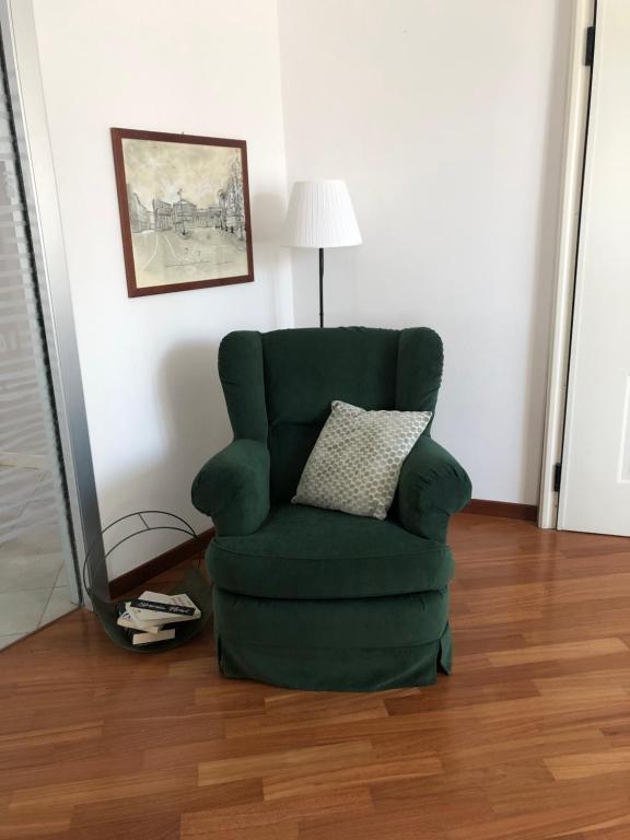 a green chair with a pillow in a room at Casa mia a Nervi in Genoa
