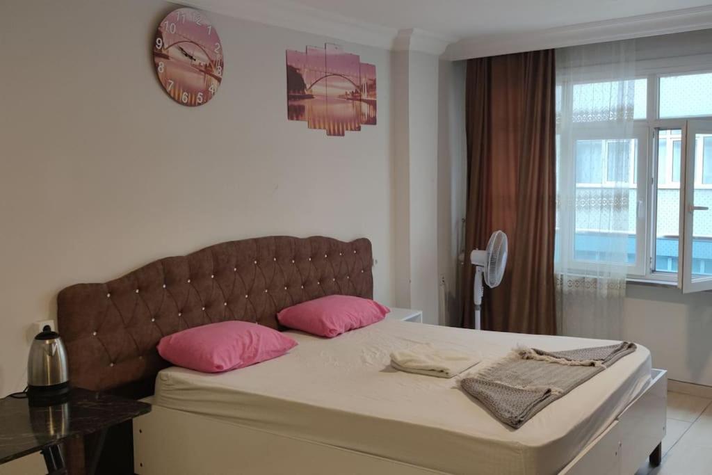 1 dormitorio con 1 cama grande con almohadas rosas en Midtown Hotel Apartments 202(0+1), en Estambul