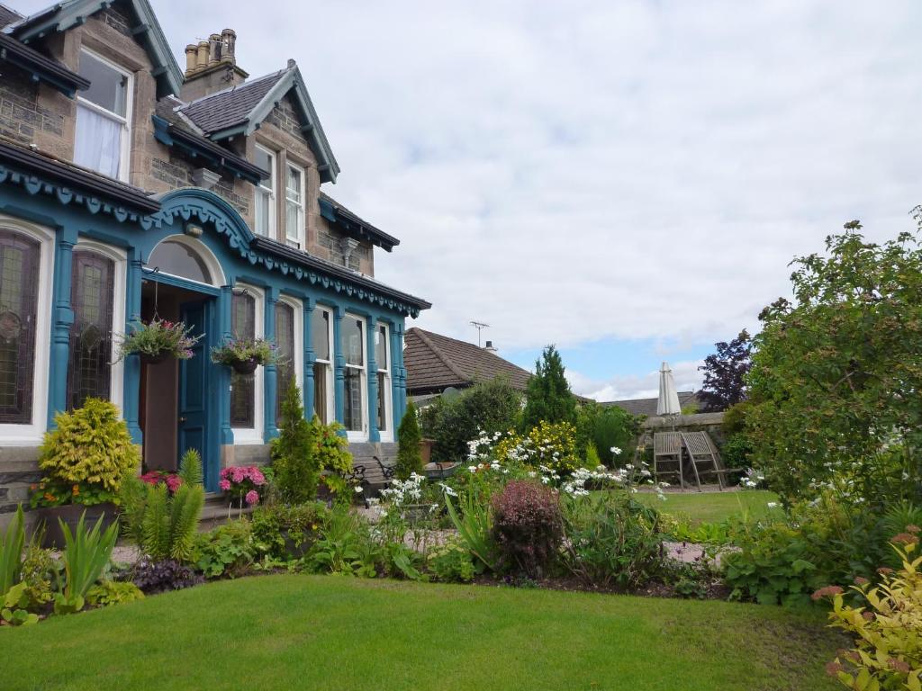 una casa con un jardín delante de ella en Dunallan Guest House, en Grantown-on-Spey
