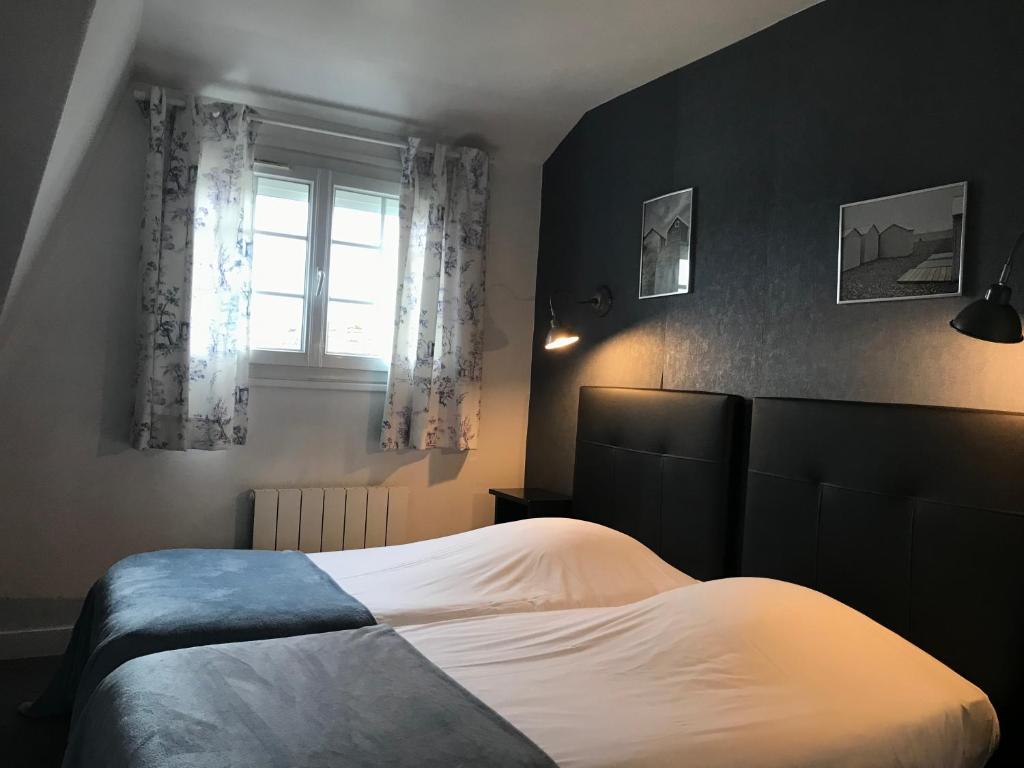 a bedroom with a bed and a window at Logis Hôtel-Restaurant Les Airelles in Neufchâtel-en-Bray