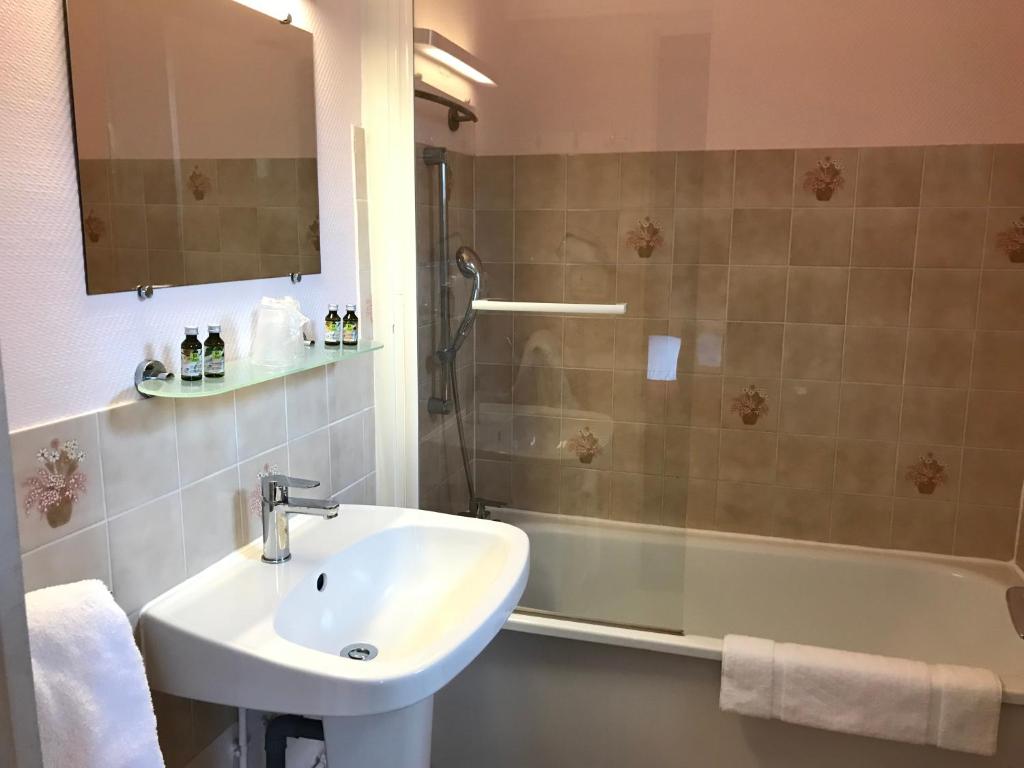 a bathroom with a sink and a shower and a tub at Logis Hôtel-Restaurant Les Airelles in Neufchâtel-en-Bray