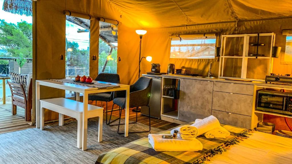 a room with a kitchen and a table in a tent at African Safari Canvas Lodge Tent Sea View in Kranidi