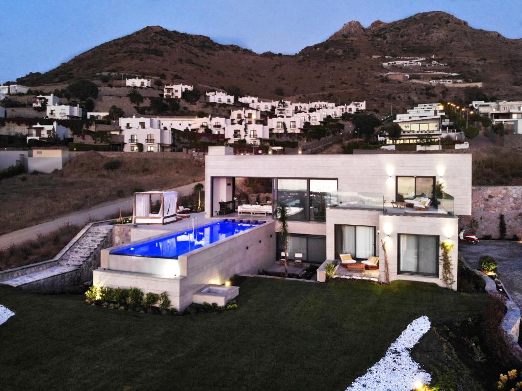 a house with a swimming pool in front of a mountain at Vistaport B - Luxury Villa in Bodrum City