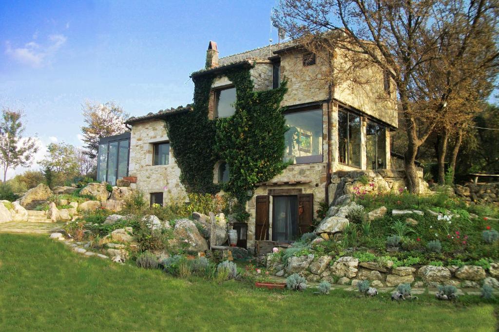 a stone house with a garden in front of it at Agriturismo Fontenuova in Saturnia