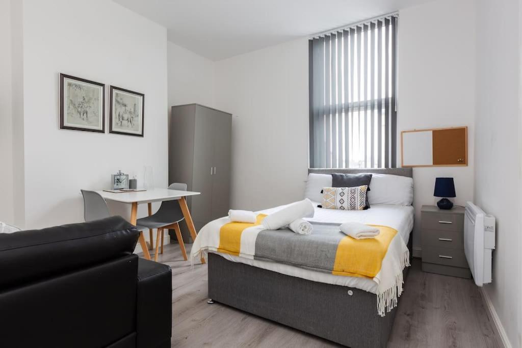 ein Schlafzimmer mit einem Bett, einem Schreibtisch und einem Sofa in der Unterkunft St Marys Studios-Free Street Parking in Liverpool