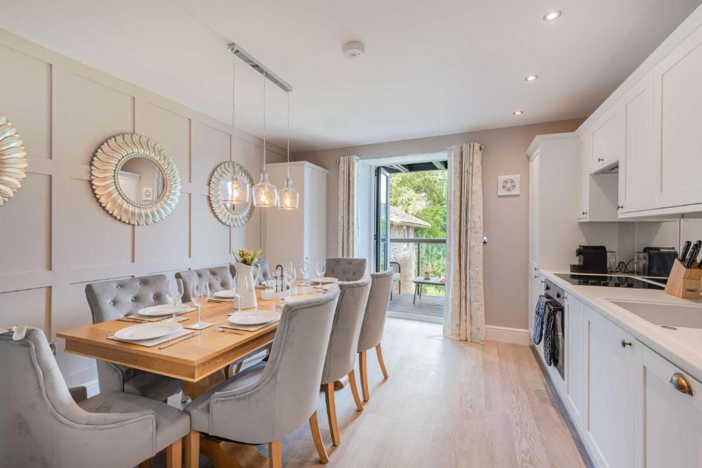 una cucina e una sala da pranzo con tavolo e sedie in legno di Belsfield Cottage a Bowness-on-Windermere