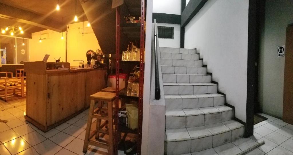 uma escada que leva a um restaurante com uma mesa e uma escada em CoffeeBunk Hostel em Tangerang