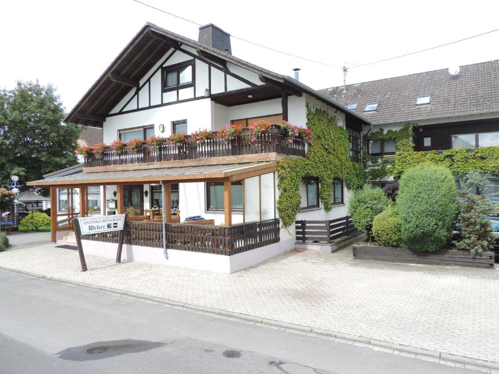 a house with a balcony with flowers on it at Gasthaus Weber in Wiesemscheid