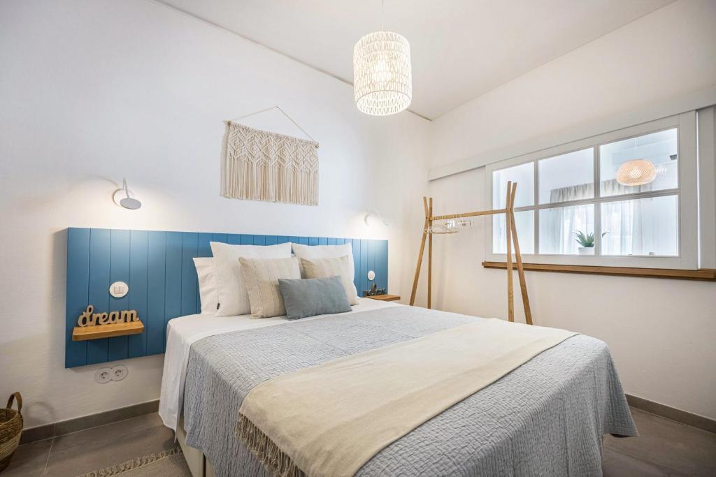 1 dormitorio con 1 cama grande y pared azul en Casa Mateus, en Vila do Bispo