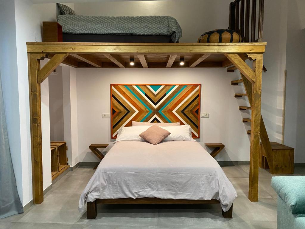 ein Schlafzimmer mit einem Etagenbett mit Leiter in der Unterkunft Apartamentos La Cámara II Córdoba Corredera in Córdoba