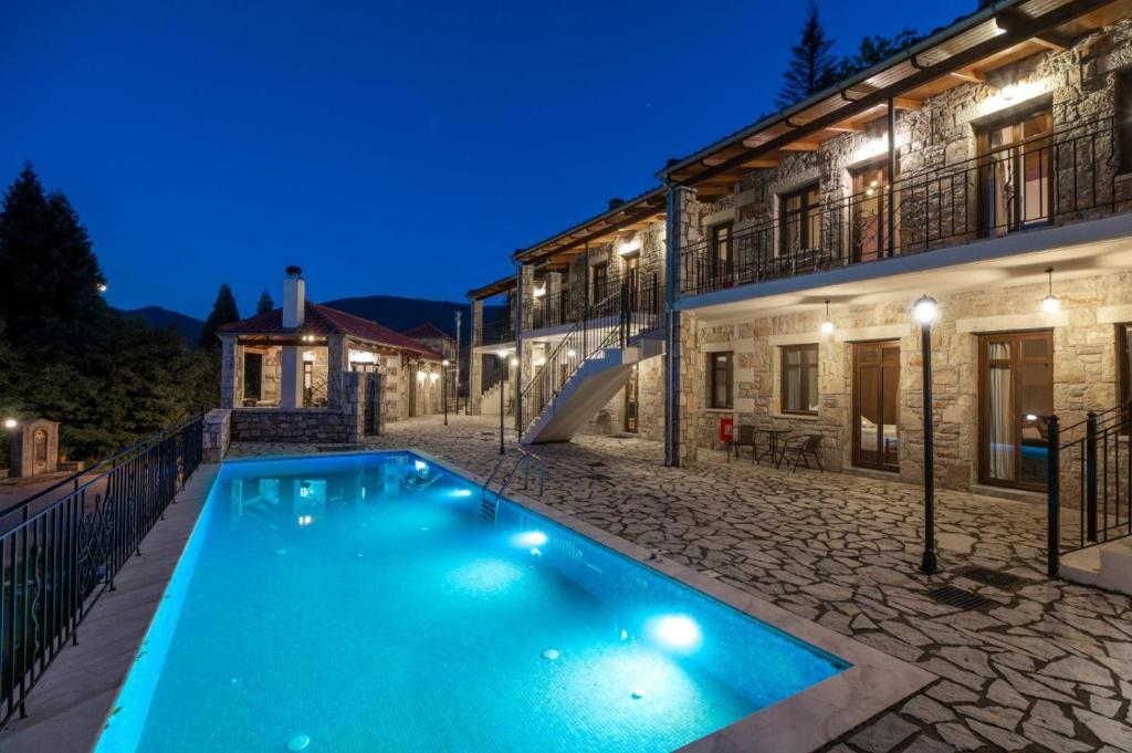 a villa with a swimming pool at night at OREADES-HOMES in Ano Chora