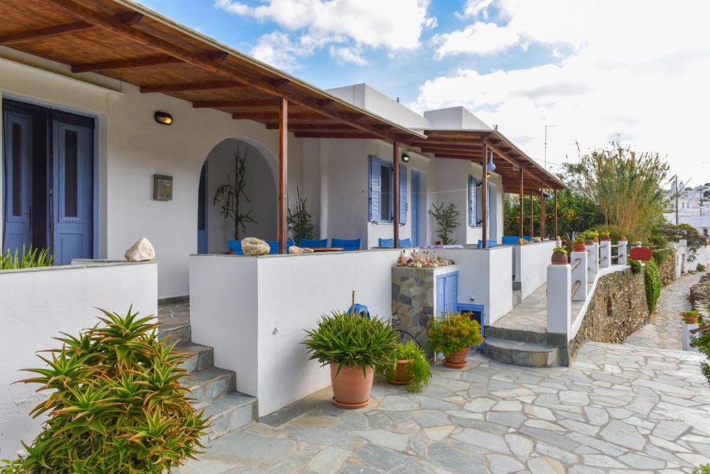 a house with white walls and blue doors and plants at Katerina Studios Mparou in Apollonia