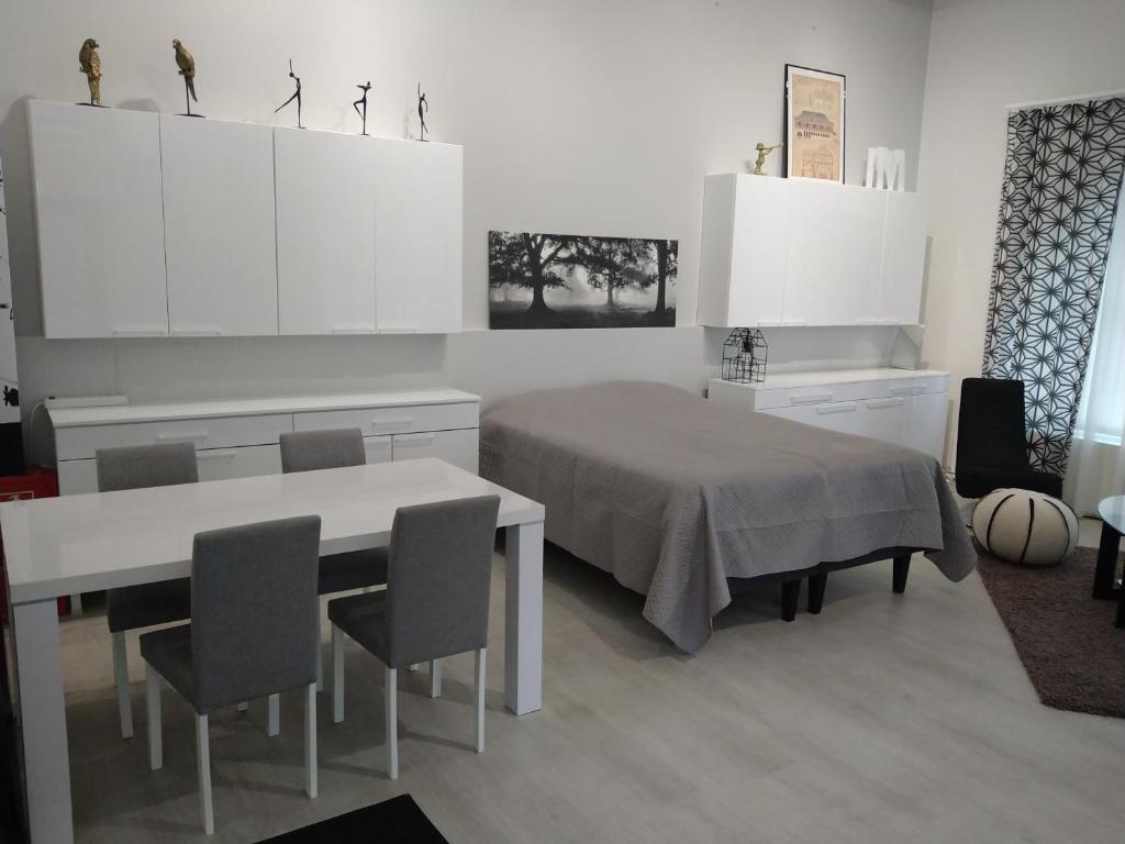 a room with a table and a bed and white cabinets at Apartment Satama in Kuopio