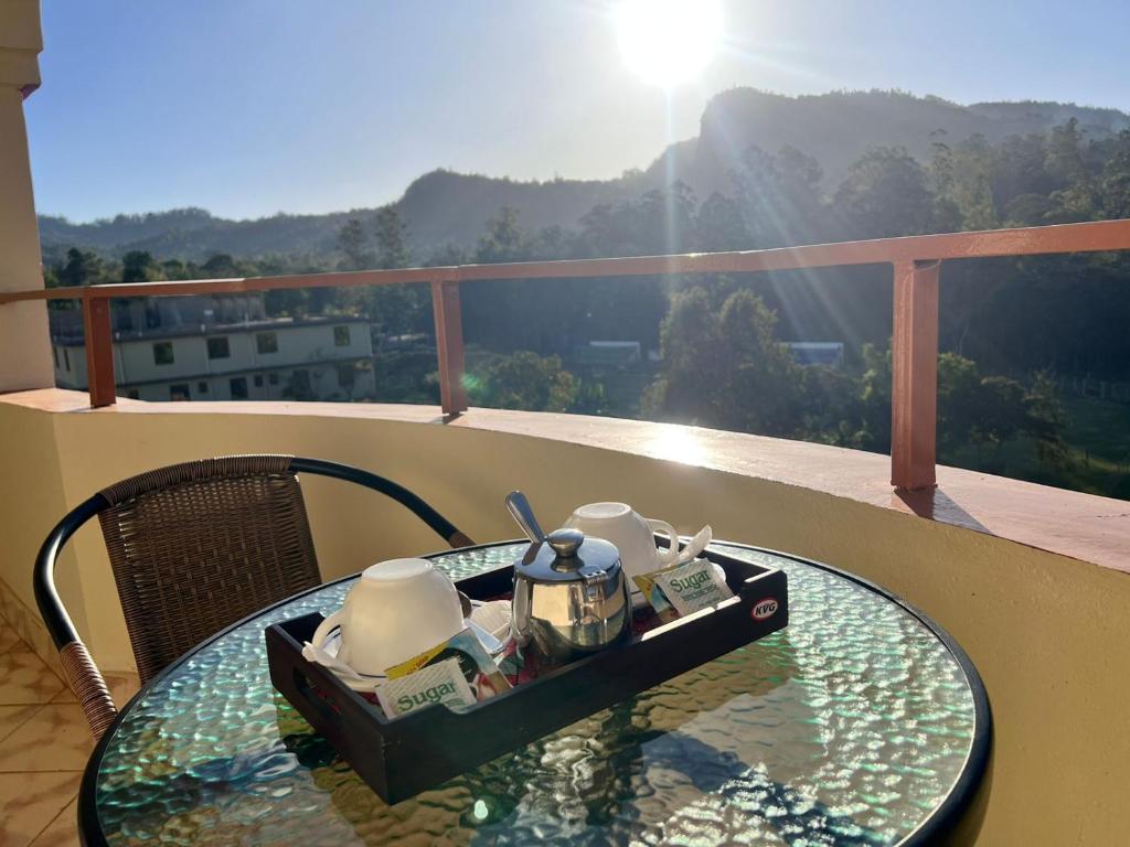 - une table en verre avec un service à thé sur le balcon dans l'établissement Lavender Garden Hotel, à Tsavo