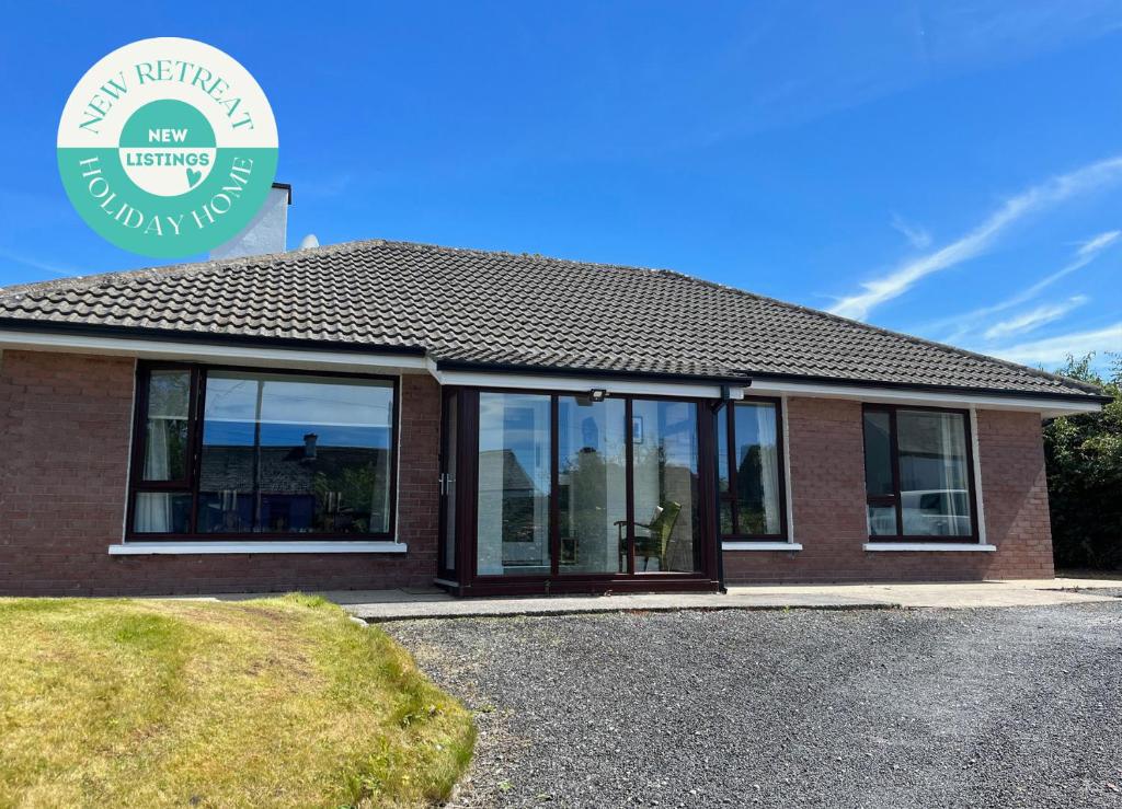 a house with large glass windows on the side of it at The Nook Oranmore Holiday Home in Oranmore