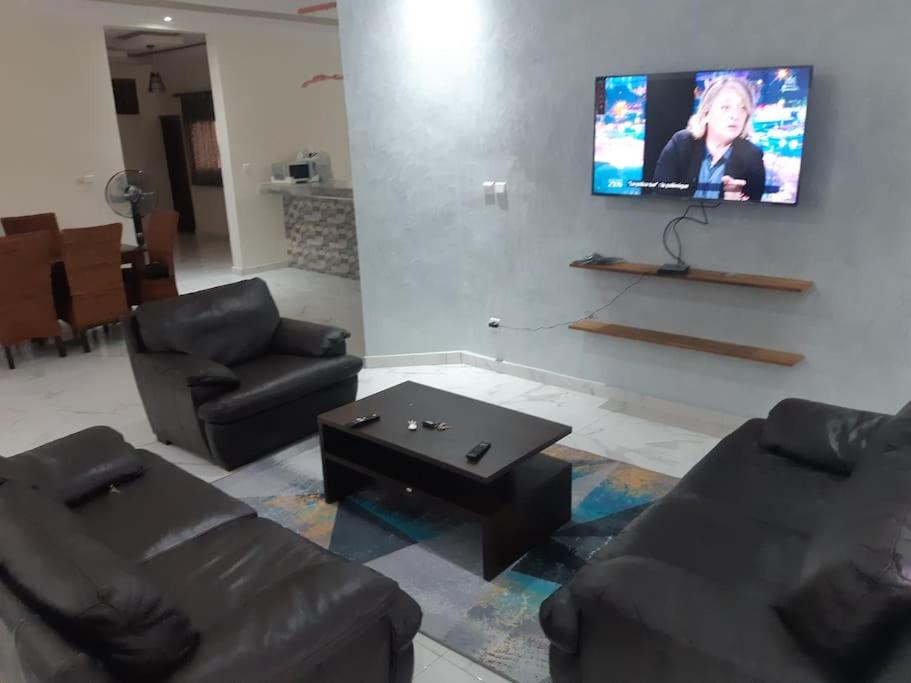 un salon avec des canapés et une télévision à écran plat dans l'établissement Appartement entier proche de la plage Yoff BCEAO A2, à Dakar