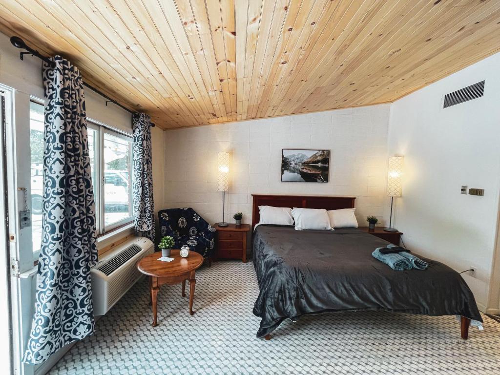 a bedroom with a bed and a wooden ceiling at Sussex Motel in Wantage