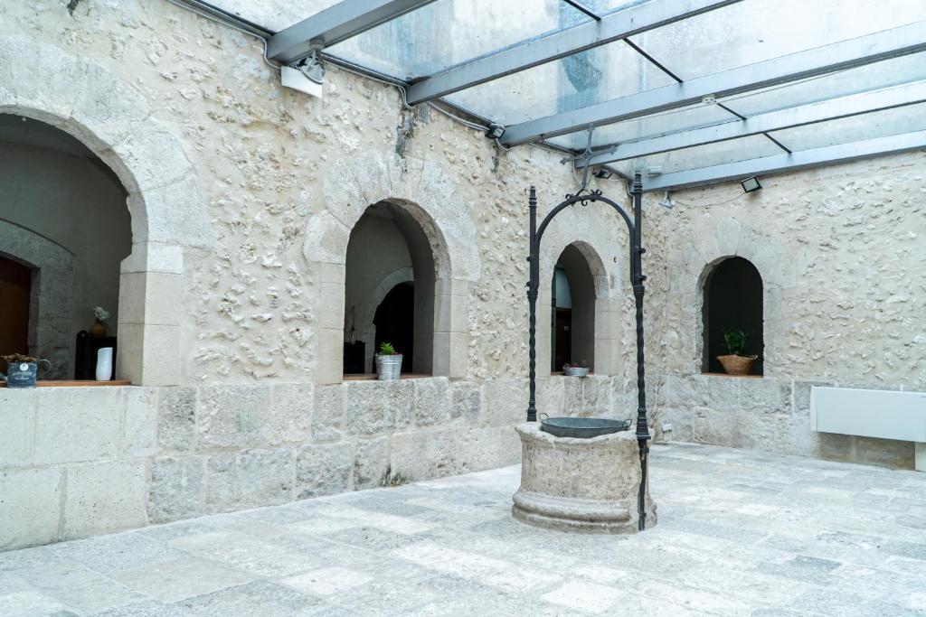 un patio con una fuente en un edificio de piedra en Albergue de Cuéllar, en Cuéllar