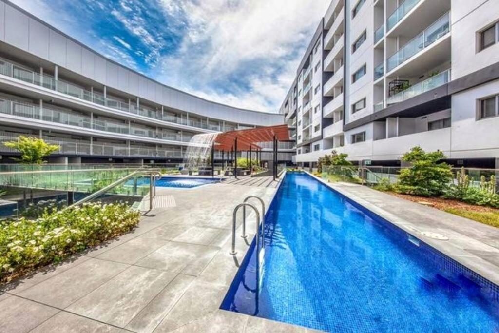 a swimming pool in front of a building at Entire apartment with lake view in Tuggeranong