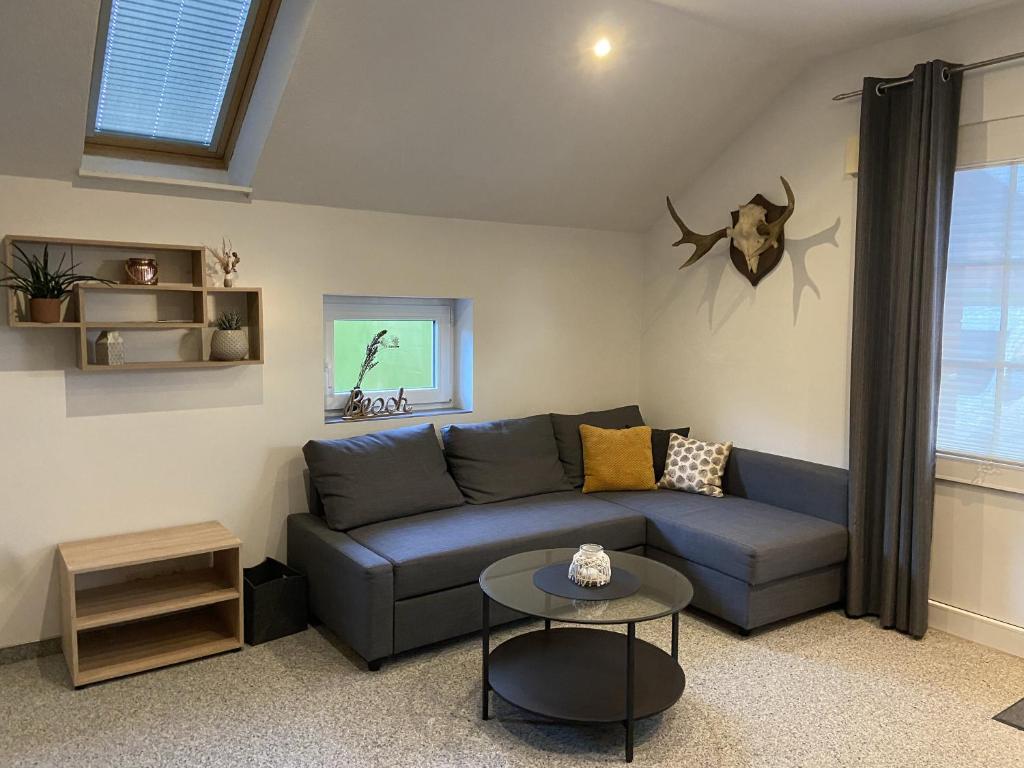 a living room with a blue couch and a table at Ferienwohnung Strackholt in Großefehn 