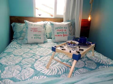 Een bed of bedden in een kamer bij Stúdio inteiro em casa familiar-ar cond próx praia