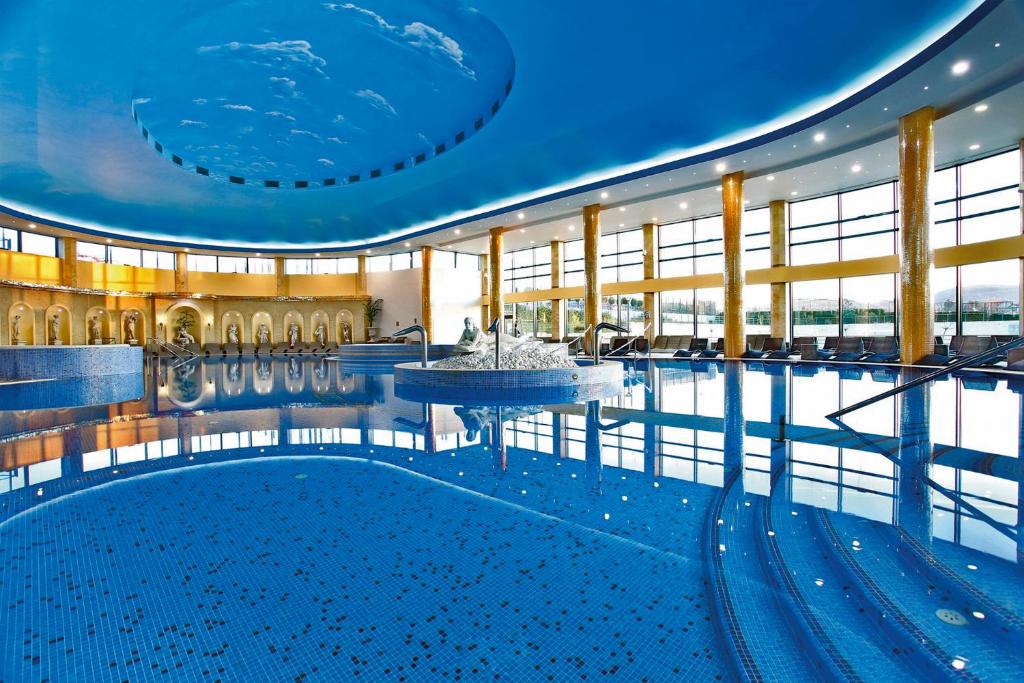 a large pool with a fountain in the middle of a building at A Hoteli - Hotel Izvor in Arandelovac