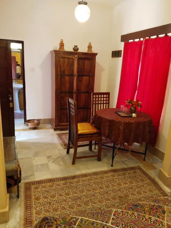 a living room with a table and a red curtain at Killa Bhawan Lodge in Jaisalmer