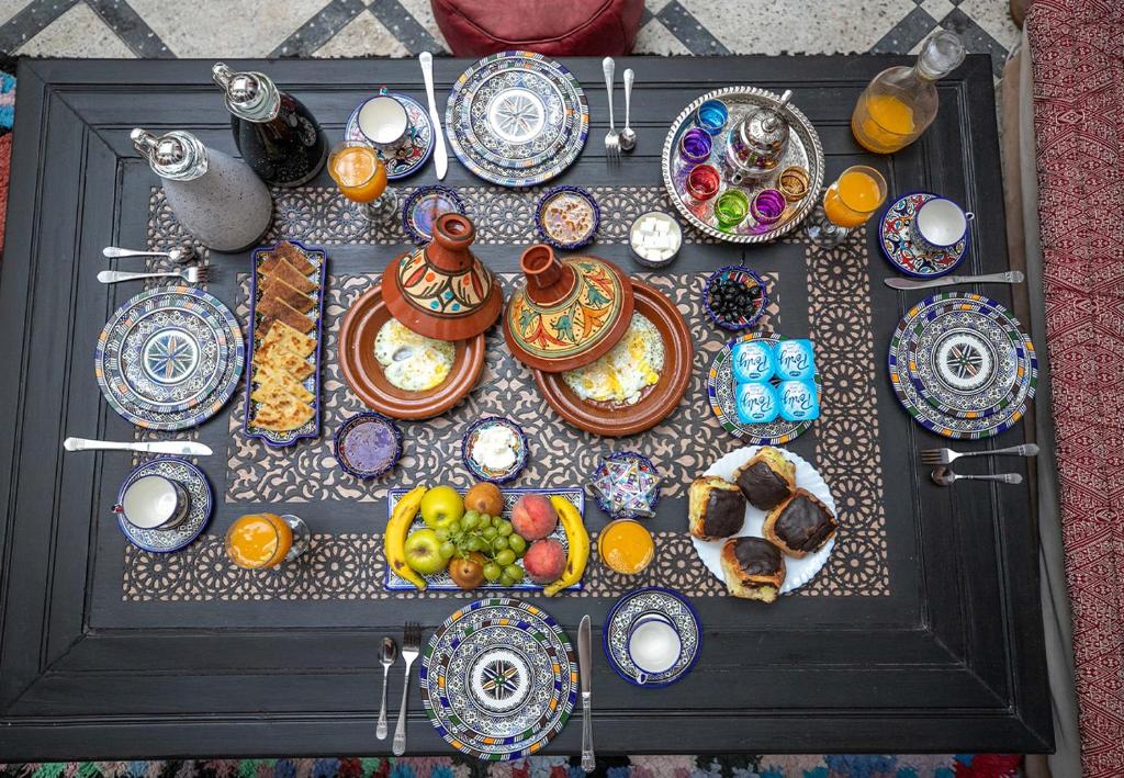 une table avec des assiettes de nourriture au-dessus dans l'établissement Riad Dar Jeanne, à Fès